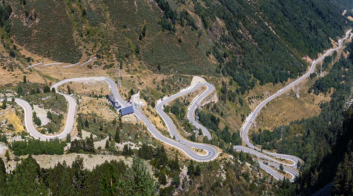 Aerial view of a winding mountain road surrounded by trees